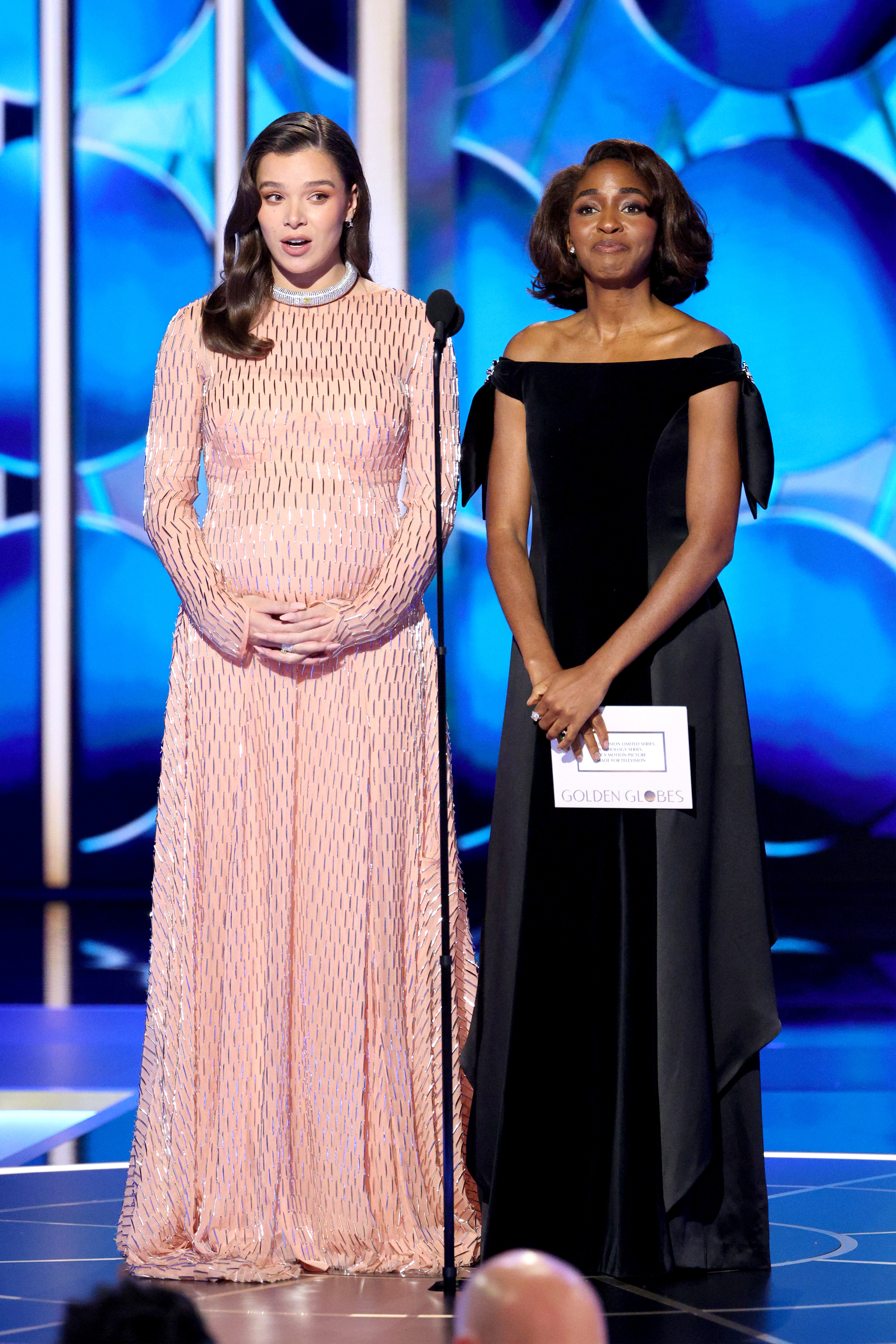 Hailee Steinfeld shows off her baby bump wearing a peach Prada dress at the 2026 Golden Globes while presenting an award with Ayo Edebiri