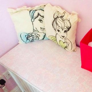 cartoon printed cushions with pink walls and white pink cabinet