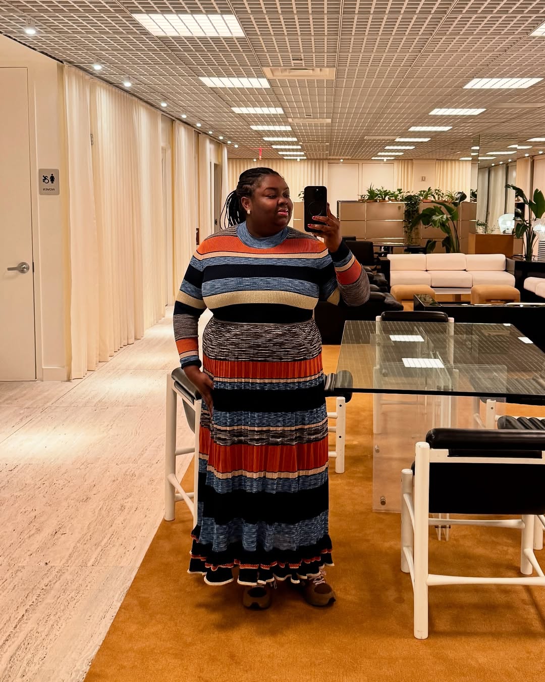 Abisola in a striped knit dress in the office