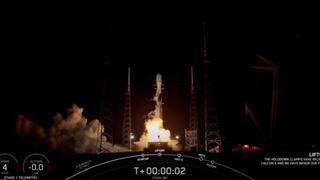 a black and white spacex falcon 9 rocket launches at night.