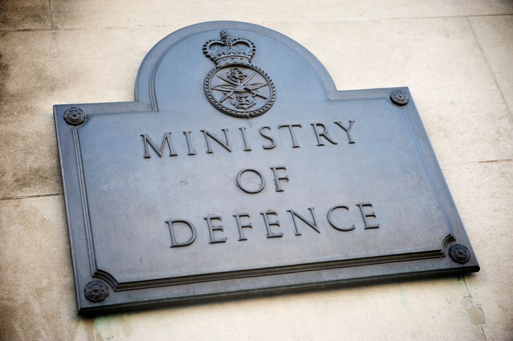 Old brass sign marking the offices of the British Ministry of Defence on a building in Whitehall, London, UK