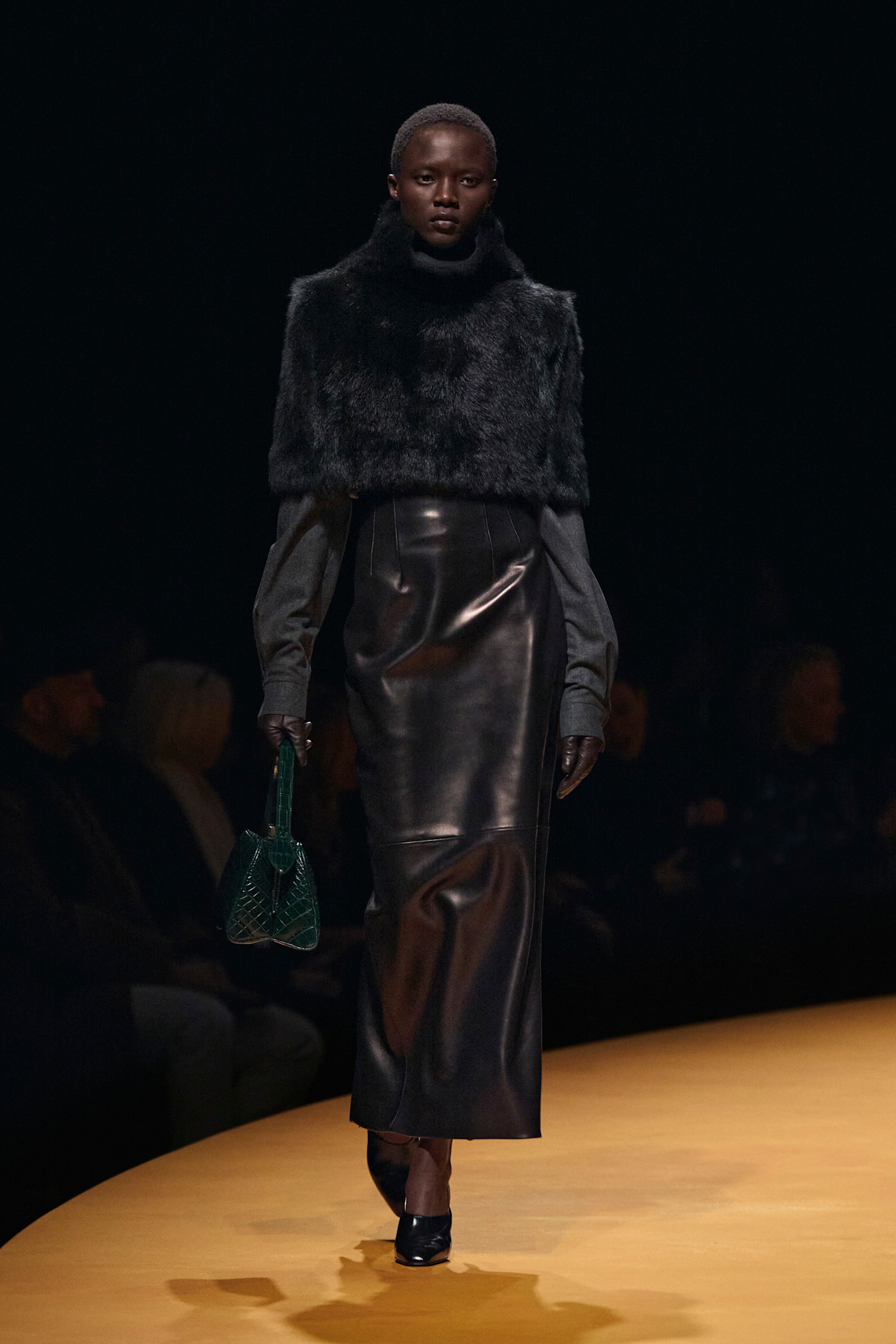 A Khaite model wearing a black fur shawl at the F/W 25 show.