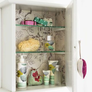 bathroom with cupboard and wallpaper