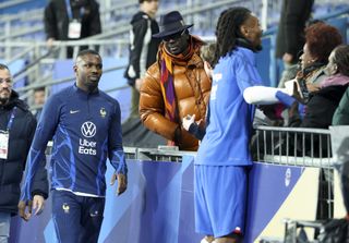Lilian Thuram watches on as sons Marcus and Khephren Thuram walk by following France's Nations League game against the Netherlands in March 2023.