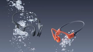 Two pairs of Shokz OpenSwim Pro headphones in water with air bubbles