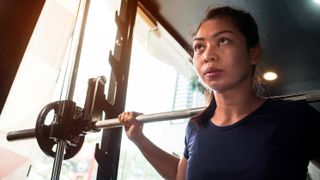 Woman uses smith machine in gym