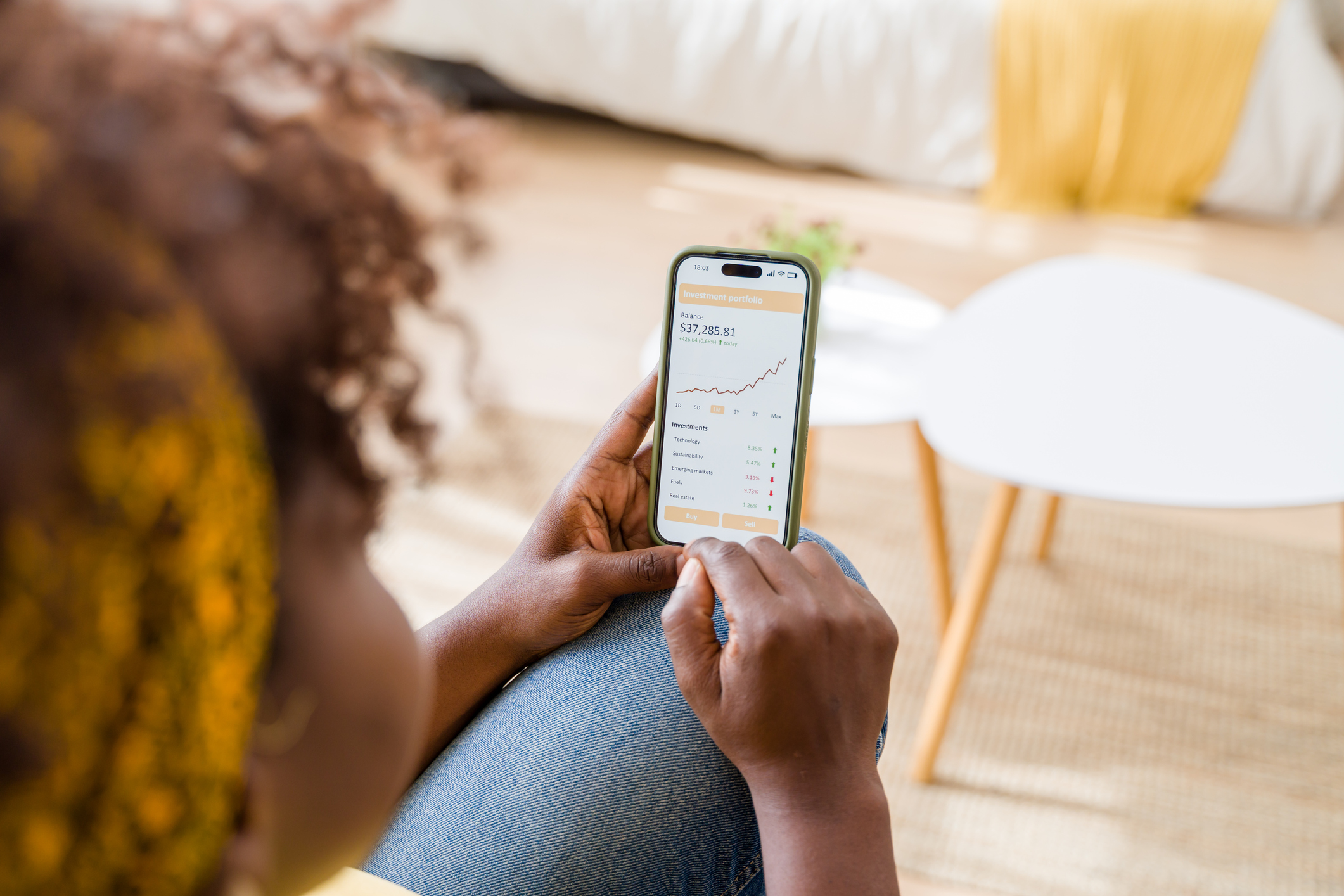 Woman is checking her investments in stocks, funds and investment trusts using a financial app on her smartphone