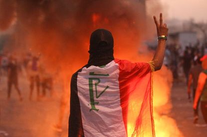 A protester makes the peace sign in Baghdad.