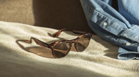 Dark glasses pictured against a denim jacket