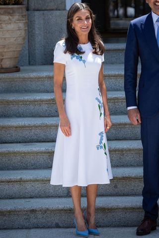 Queen Letizia wearing a white dress with blue pattern