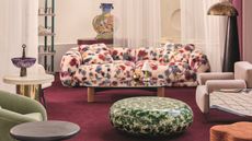 a living room with a colorful carpet and a splattered color couch