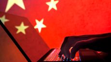 Chinese hacker concept image symbolizing the Salt Typhoon threat group, with a man typing on keyboard with People's Republic of China (PRC) flag in background.