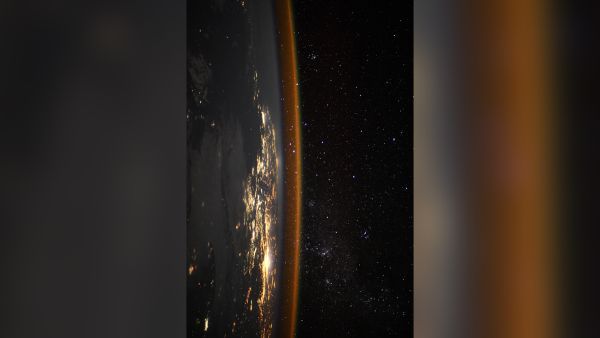 The sideways Earth glimmers in this photo taken from the International Space Station