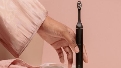 Suri toothbrush review: A woman picking up a suri toothbrush