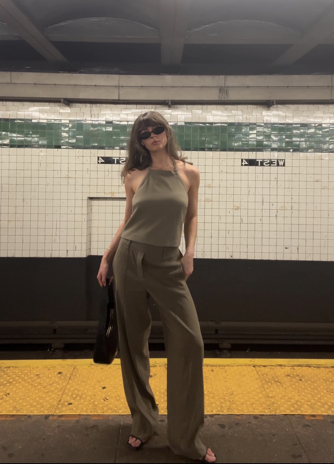 Kathryn Zahorak at subway platform wearing green tank top and pants