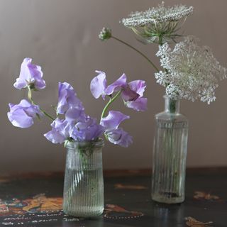 Dark wood table with clear glass vases with flowers in.