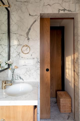 A small bathroom with marble sink and walls
