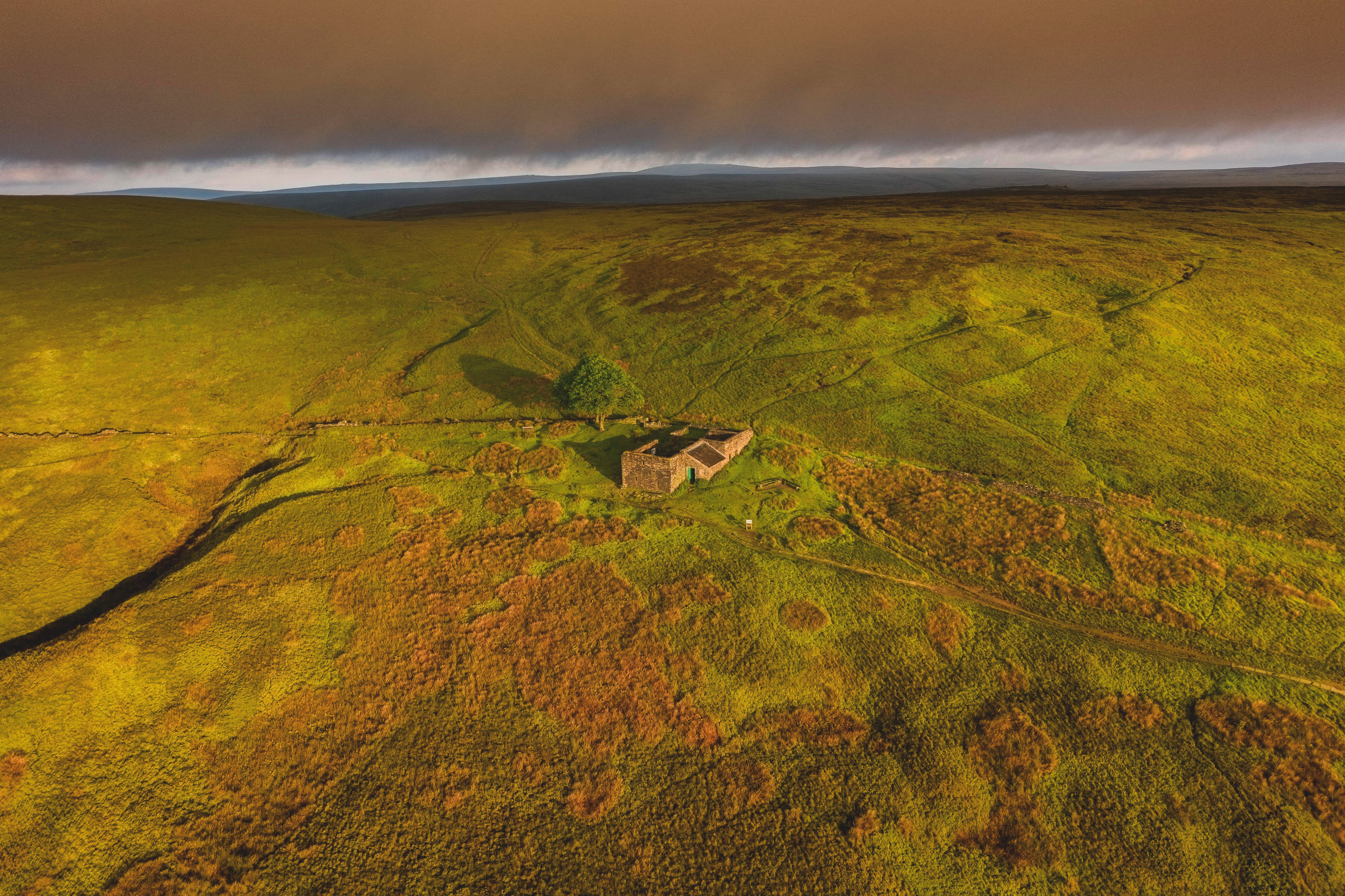  An aerial Sunrise drone shot of Top Withens or Top Withins, this farmhouse has been associated with Wuthering Heights.