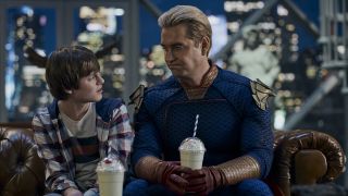 Homelander holding a milkshake while sitting on the couch talking to Ryan in The Boys Season 4