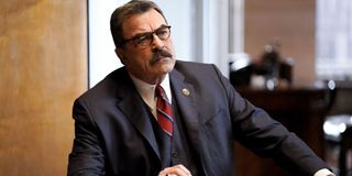 Tom Selleck looking serious and sitting at a desk.