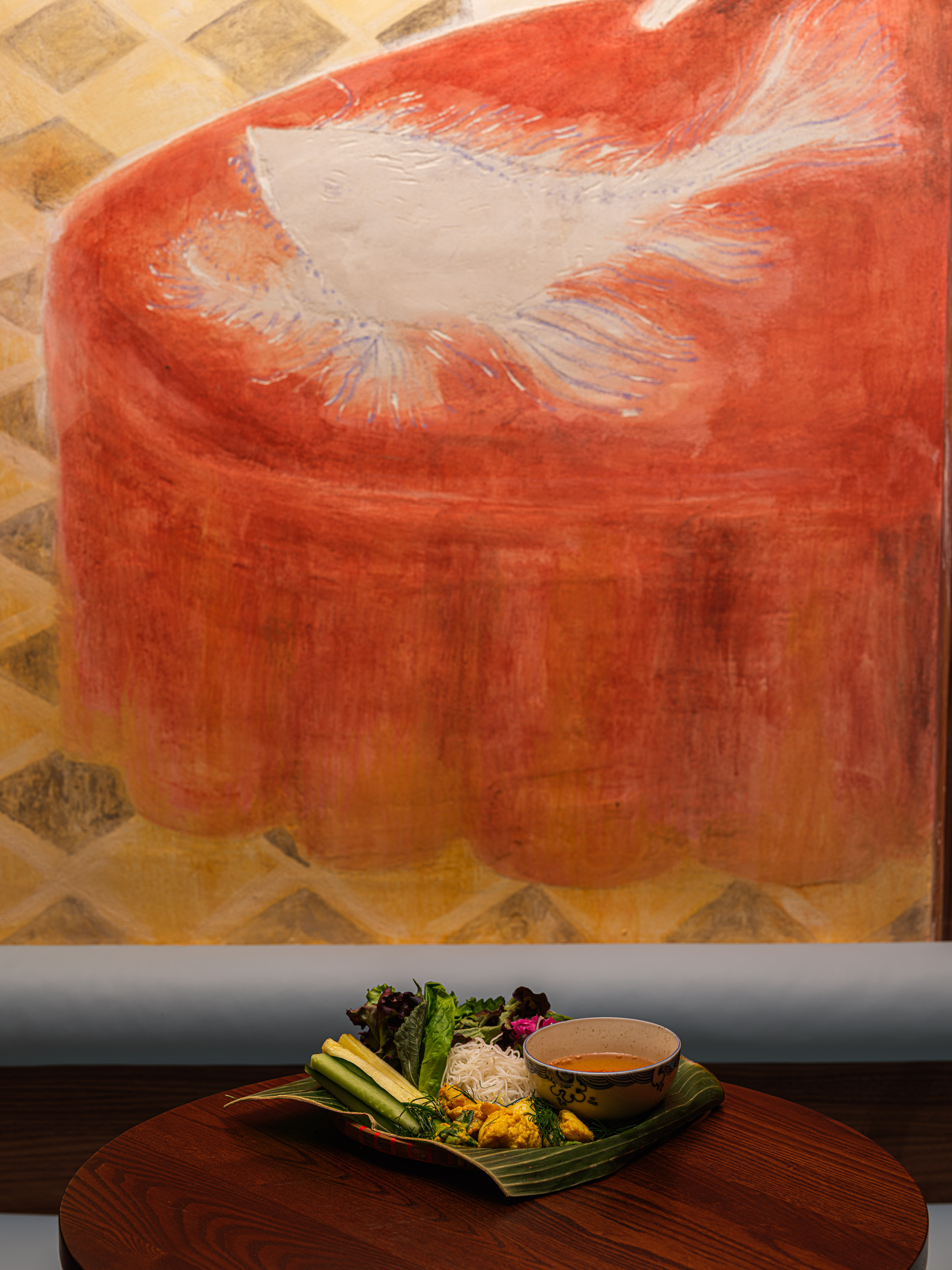 A dramatically lit and designed restaurant pairing cement walls with hand-painted wooden panels, murals, terracotta tiles, chrome accents, and glass blocks.