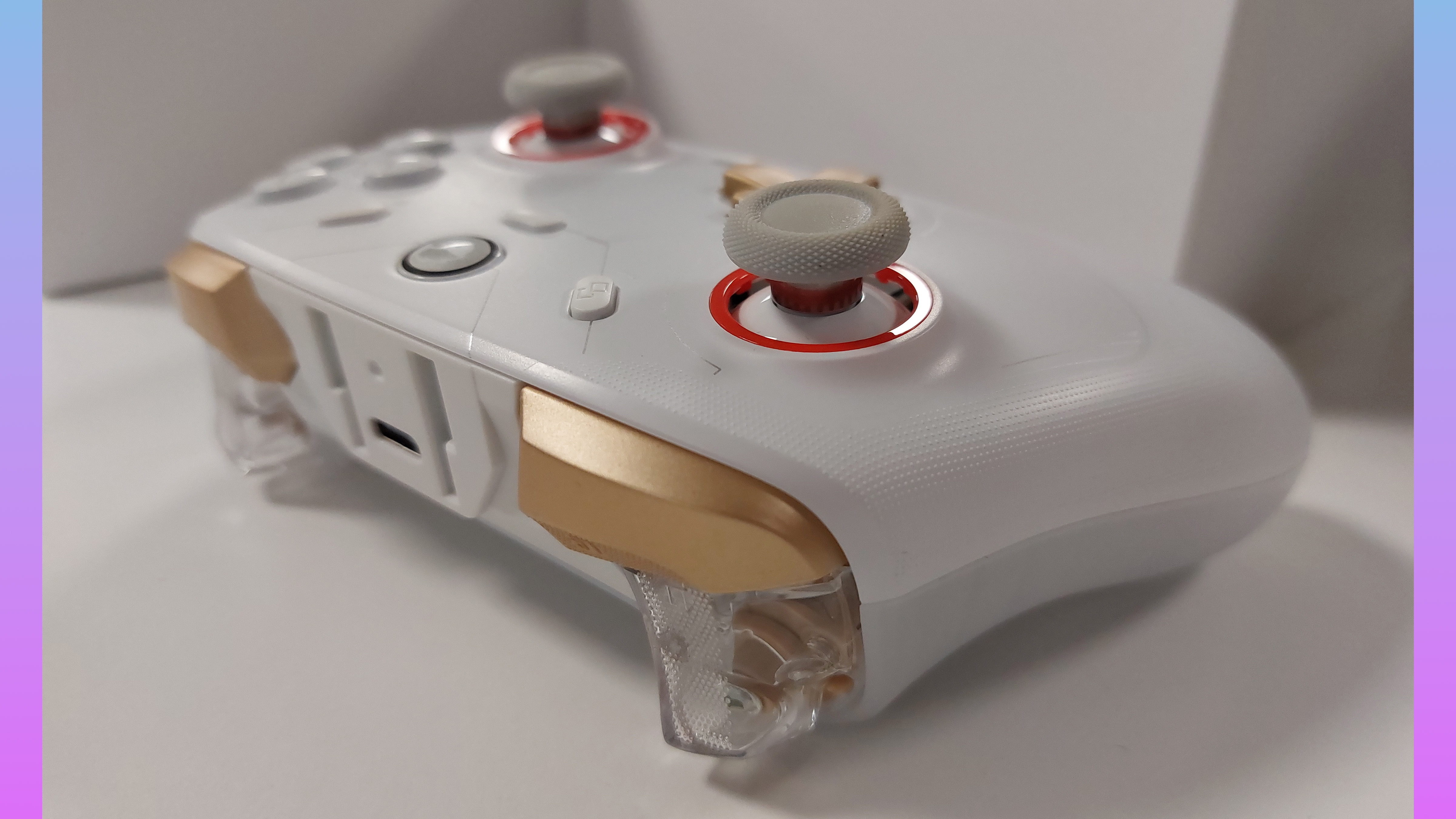 The GameSir Cyclone 2 controller in Phantom White. This colourway features a white gamepad body, a golden D-pad, golden shoulder buttons, clear plastic triggers, grey thumbstick covers with orange thumbstick inlays, and silver text accents. The RGB lights are switched off in this image.