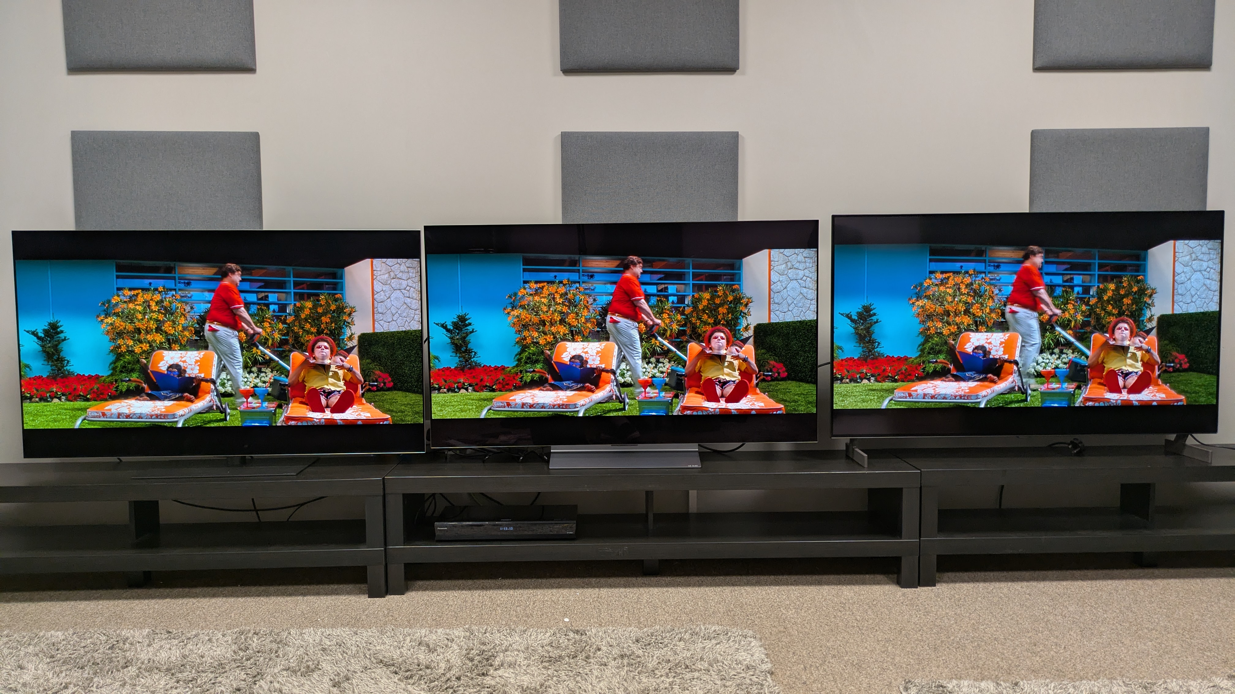 LG G6 (left) vs LG C6 (middle) vs LG B6E (right) showing Pops Racer walking mowing a lawn behind a sunbathing Spritle and Chim Chim. All TVs showcase vibrant colors, especially the red of Pops's shirt