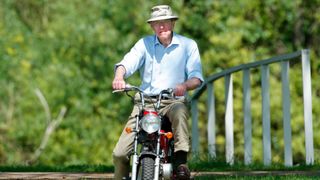 Prince Philip, Duke of Edinburgh seen riding a mini 'Easy-Rider' motorbike as he attends the Royal Windsor Horse Show in Home Park on May 16, 2002 in Windsor, England