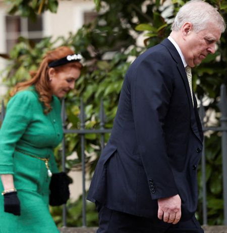 Sarah Ferguson wearing a green suit walking behind andrew Mountbatten-Windsor