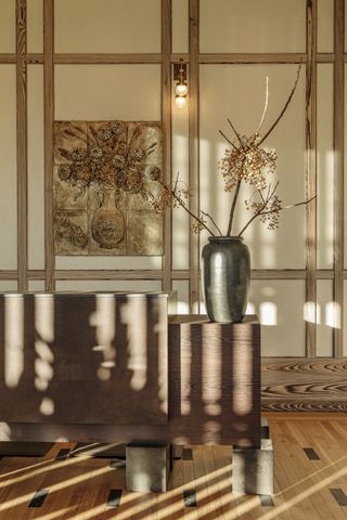 lobby with sideboard and artfully displayed vase with stems, natural tones