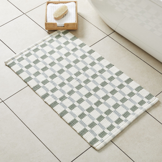 green and white plaid bathmat on a bathroom floor