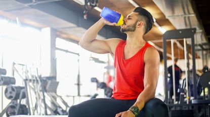 Man drinking pre-workout in the gym