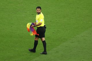 Match referee Alireza Faghani of Iran holding a Rainbow flag left by a pitch invader during the FIFA World Cup Qatar 2022 Group H match between Portugal and Uruguay at Lusail Stadium on November 28, 2022 in Lusail City, Qatar.