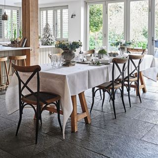 long dining table with festive tablescape and wooden chairs