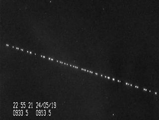 A train of SpaceX Starlink satellites are visible in the night sky in this still from a video captured by satellite tracker Marco Langbroek in Leiden, the Netherlands on May 24, 2019,