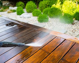 A deck being cleaned with a pressure washer