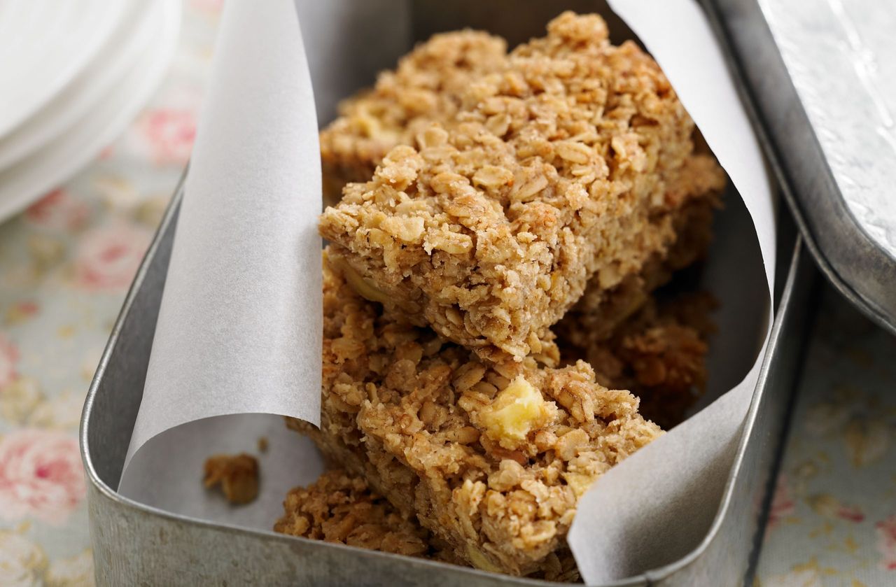 apple flapjacks wrapped in paper in a cake tin