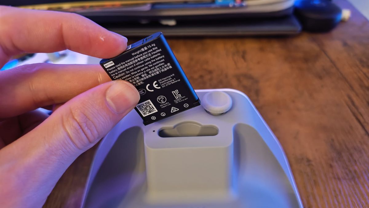A swappable battery being slotted into the charging stand of the SteelSeries Aeon Pro