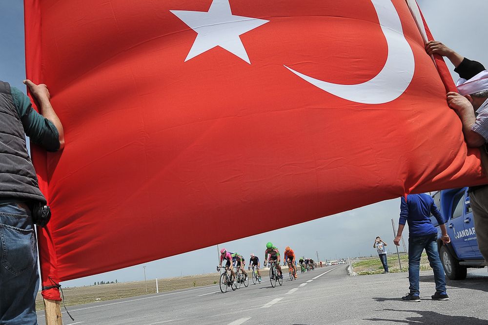 A spectator with a Turkish flag as the peloton passes