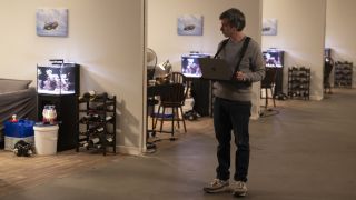 Nathan Fielder stands among a row of fake living rooms in The Rehearsal season 2