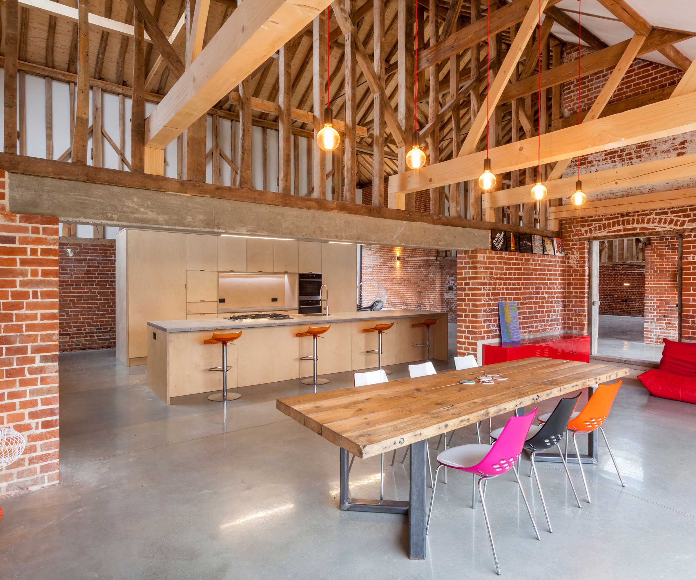 modern wooden kitchen in barn conversion with poured concrete flooring