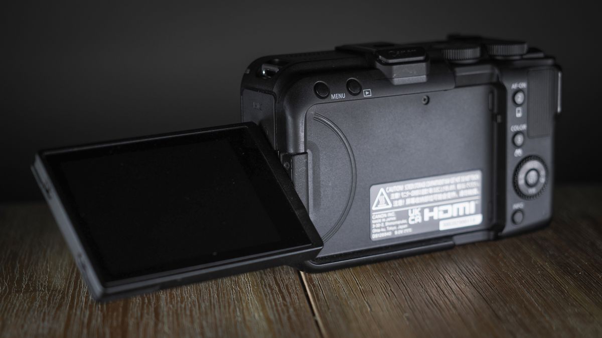 Canon EOS R50 V on a wooden surface, against a dark background