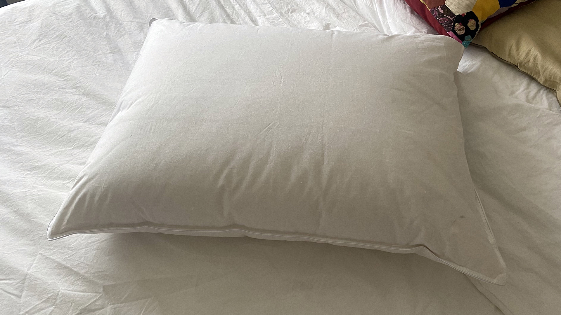 The Downright Mackenza White Down pillow on the bed in our reviewer's bedroom