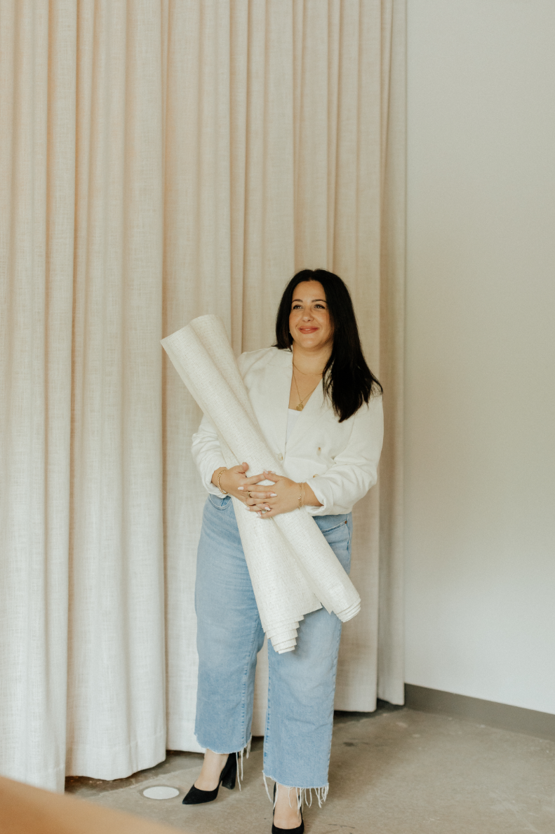 a woman standing and holding rolls of paper