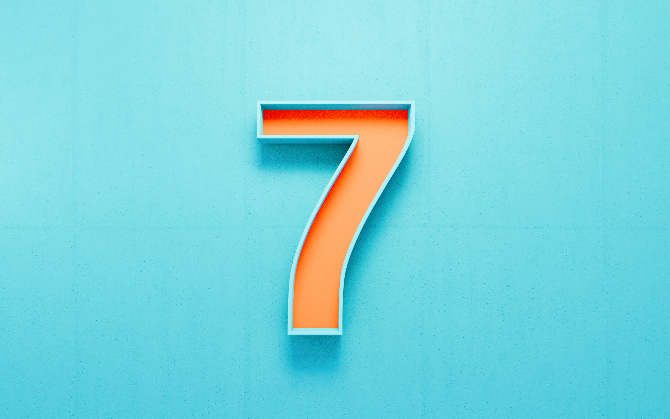 Orange number seven on blue concrete wall background. Horizontal composition.
