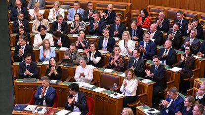 Lawmakers react after voting on an amendment to the constitution by introducing term-limits for prime ministers to a maximum of eight years in office, in the main hall of the Parliament building in Budapest, on June 15, 2026. Hungarian lawmakers on June 15 voted overwhelmingly to limit prime ministers' terms in office to a maximum of eight years, a constitutional change that blocks nationalist Viktor Orban's return. (Photo by Attila KISBENEDEK / AFP via Getty Images)