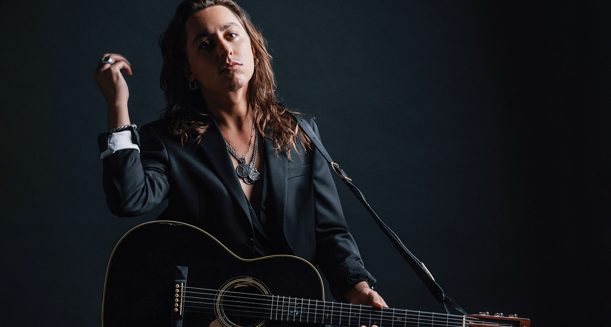 Jake Kiszka of Greta Van Fleet and Mirador wears a dark suit and is photographed with his trusty Gibson SG