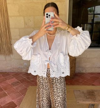 Woman in blouse and leopard print pants.