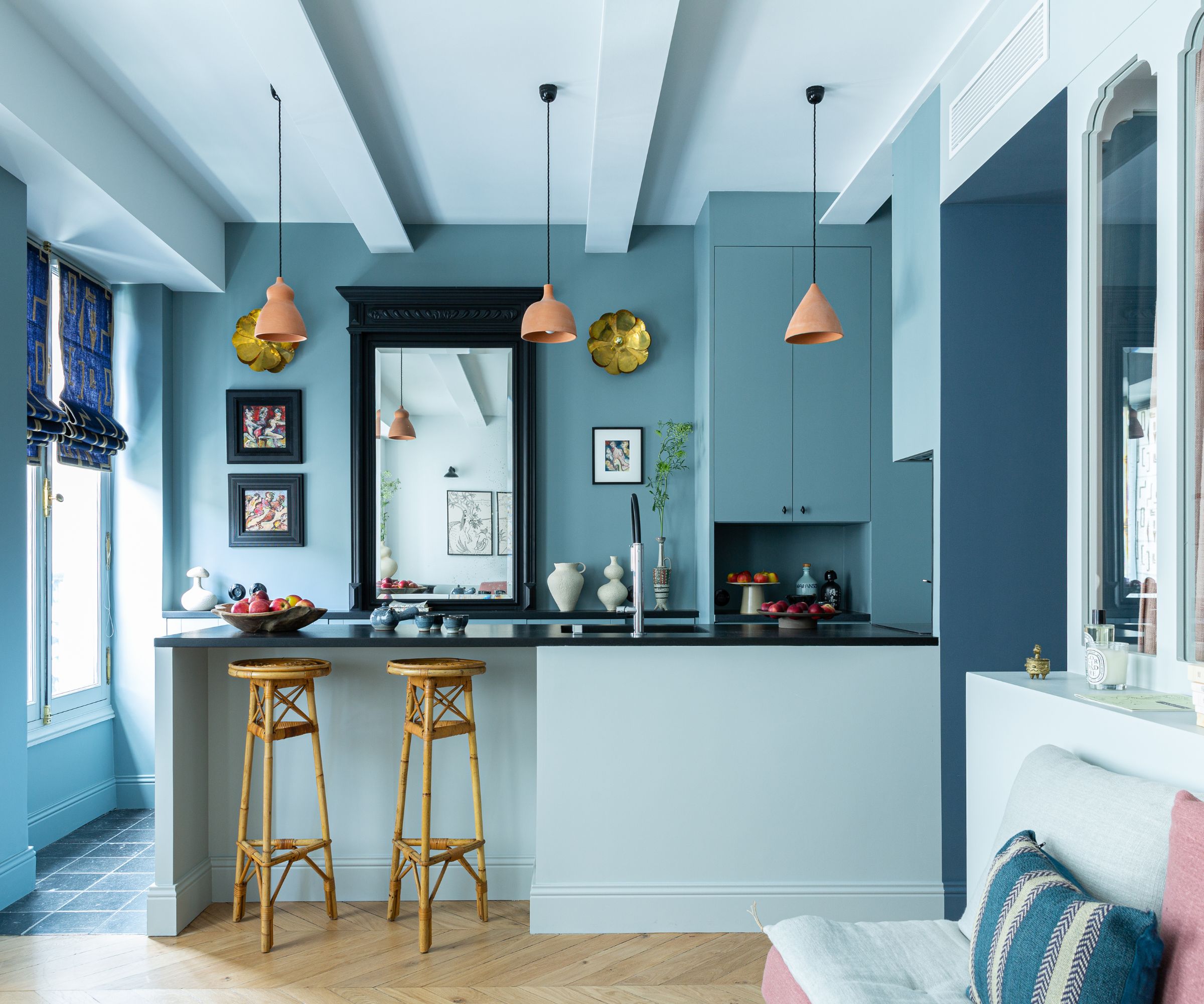 Open plan apartment with blue kitchen and island and large windows