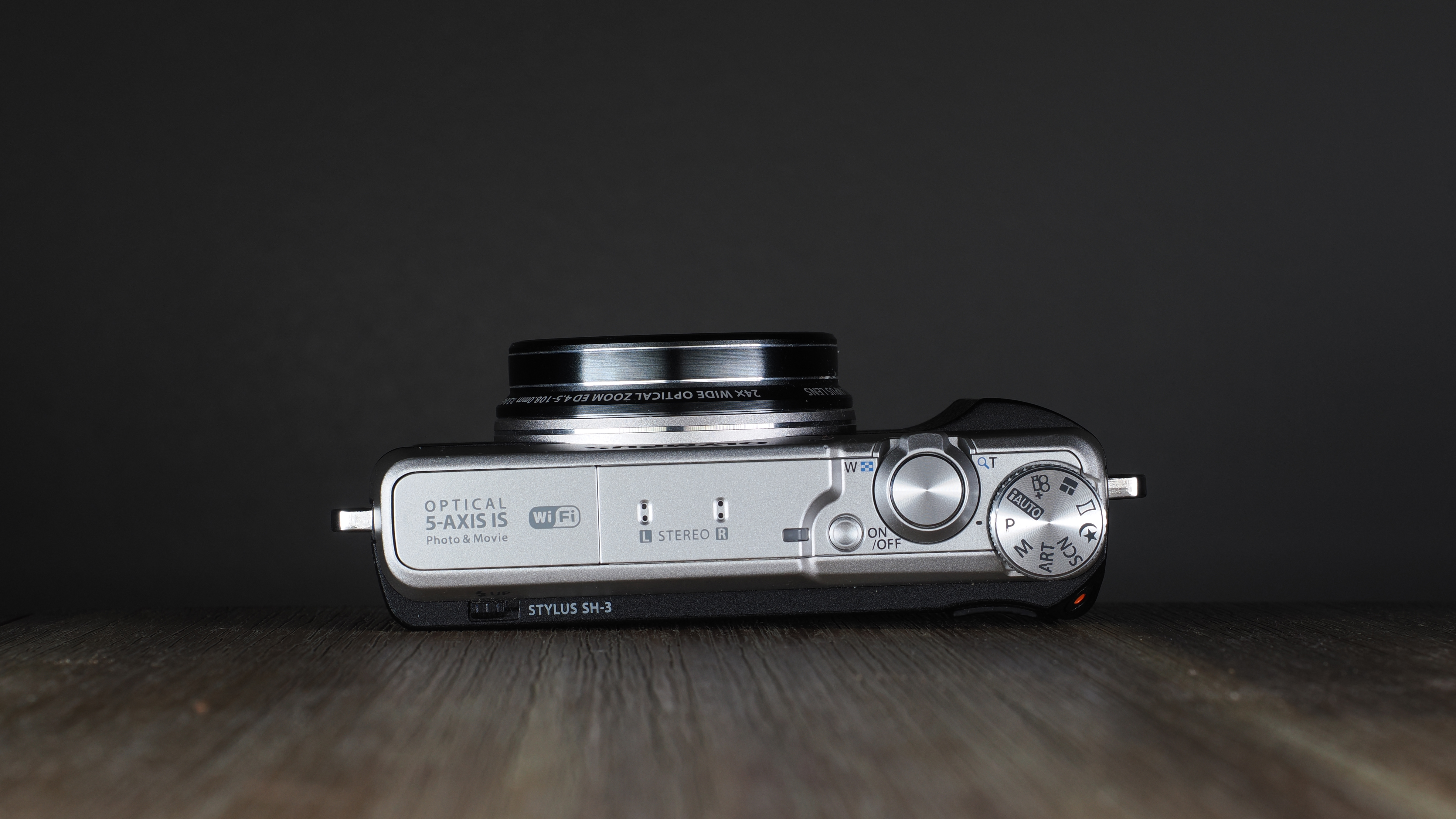 Olympus Stylus SH-3 on a wooden surface